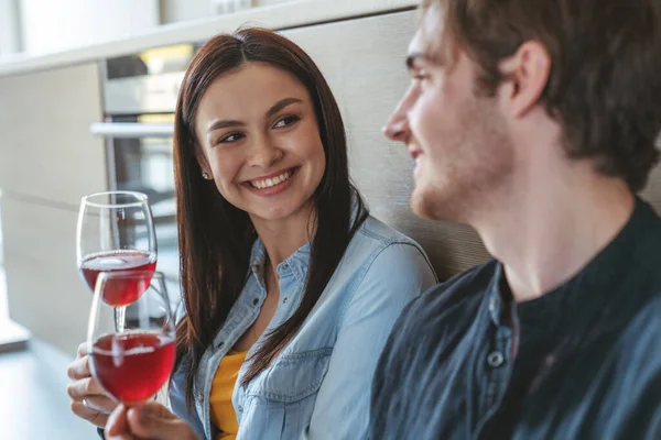 一对快乐的年轻夫妇的画像 他们坐在厨房的地板上 用杯子喝酒 谈着什么有趣的事 — 图库照片