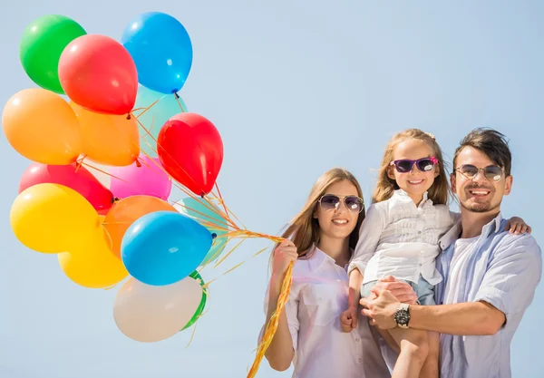 Familia con globos afuera — Foto de Stock
