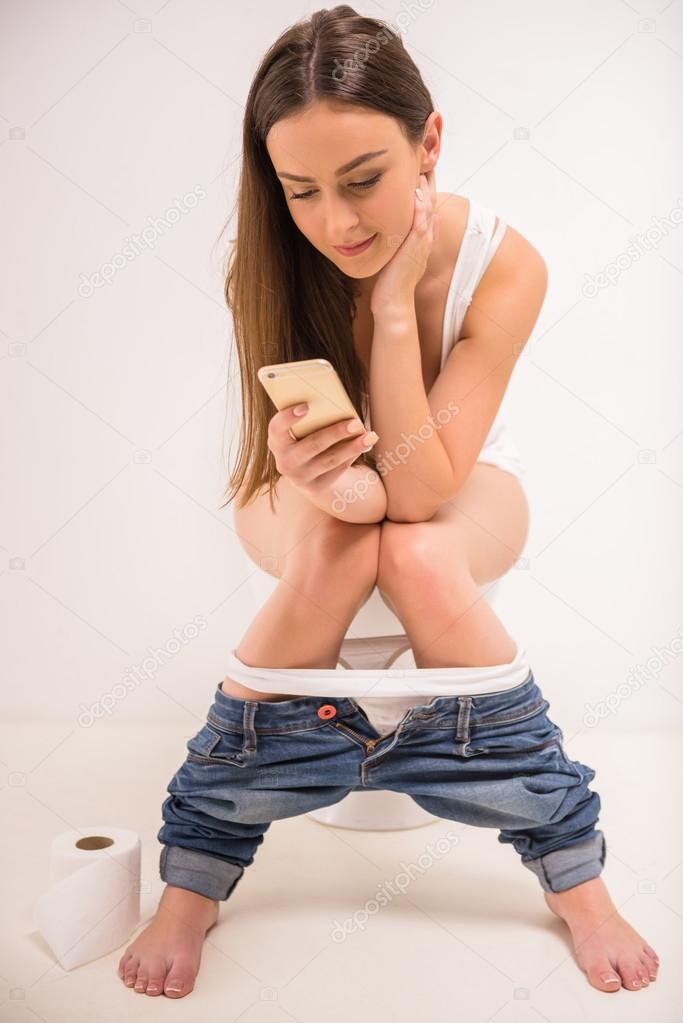 A beautiful girl is sitting on the toilet. Woman in panties relaxing on the  toilet with the phone. Pensive teenage girl sits with panties on the  toilet. 11025526 Stock Photo at Vecteezy