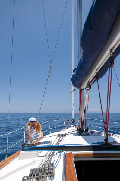 Mujer joven estilo marino está sentado en el barco y mirando hacia adelante — Foto de Stock