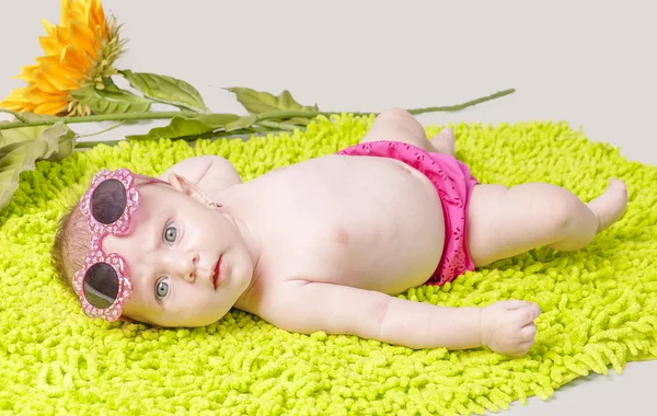 Schönes kleines Mädchen auf grünem Teppich — Stockfoto