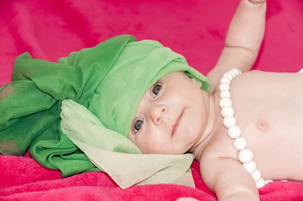 Little smiley baby girl on red blanket — Stock Photo, Image