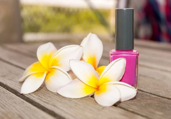 Nagellack flaska och blommor — Stockfoto