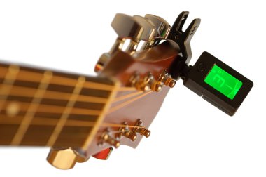Detail of acoustic guitar with guitar clip tuner clipart