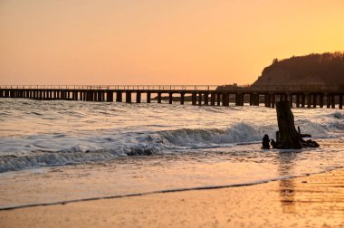 Akşamüstü, Karadeniz 'de çekilen yatay fotoğrafta gün batımında iskelenin arka planına karşı.