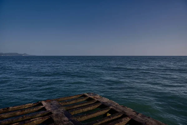 Karadeniz 'i ve gün batımında iskelenin tabanından sahili gösteren yatay bir fotoğraf.