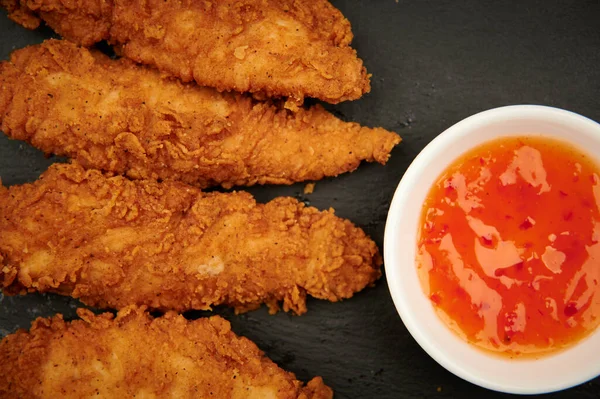 Fast food tavuk şeritleri ve kırmızı acı sos yakın yatay üst görünüm