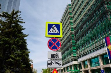 05/21/2021 Sberbank building Krasnodar Russia and road signs in a row from top to bottom pedestrian crossing, parking is prohibited, tow truck and photo fixation