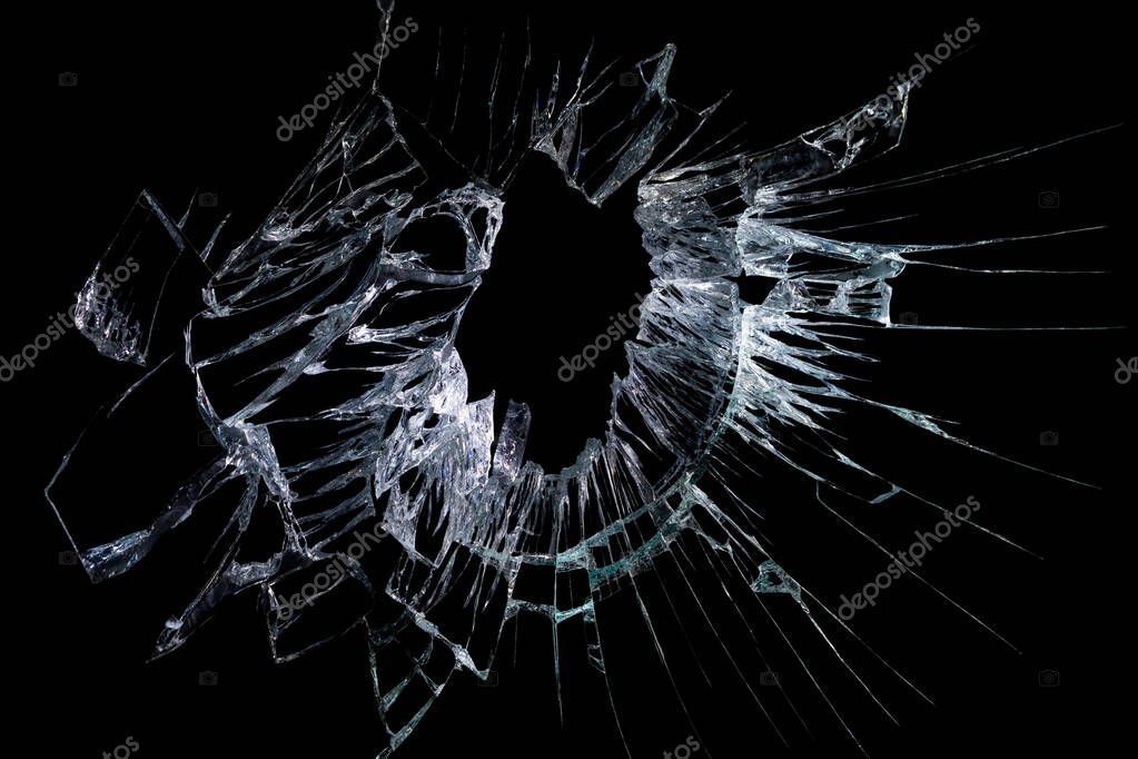 Broken mirror and glass from impact on a black background in cracks in the form of an isolated abstraction