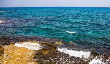 Sahilde, yükselen dalgalarla dolu bir kıyıda.