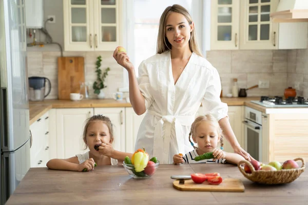 mom with two children in the kitchen at home