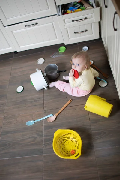 Baby plays in the kitchen, throws things around