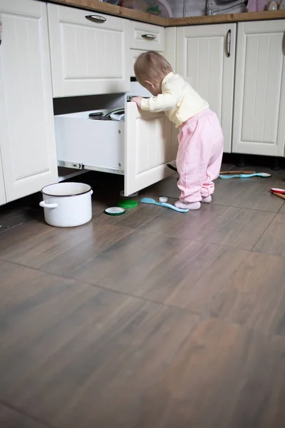 Baby plays in the kitchen, throws things around