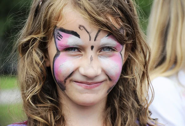 Legrační malá holčička, s malovanými tváří — Stock fotografie