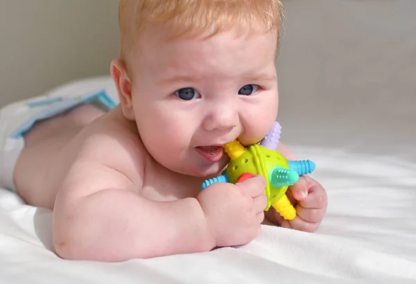 かわいい赤ちゃんはカラフルなシリコーン歯のおもちゃを噛む 子供時代のコンセプト — ストック写真