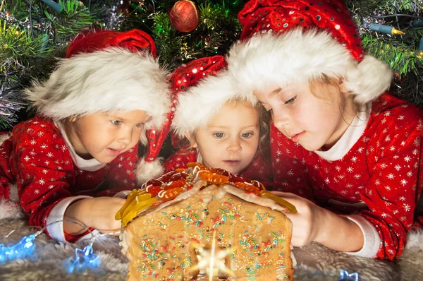 Crianças em chapéus de Papai Noel ter um Natal — Fotografia de Stock