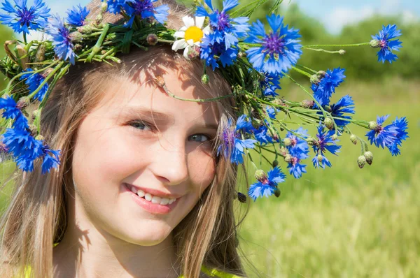 Lycklig liten flicka i blomma krona — Stockfoto