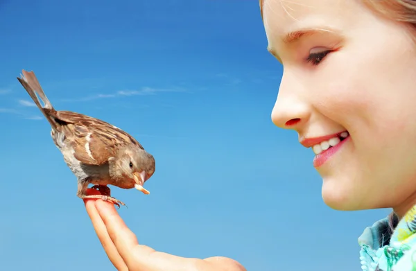 Schönes Mädchen füttert Sperling — Stockfoto