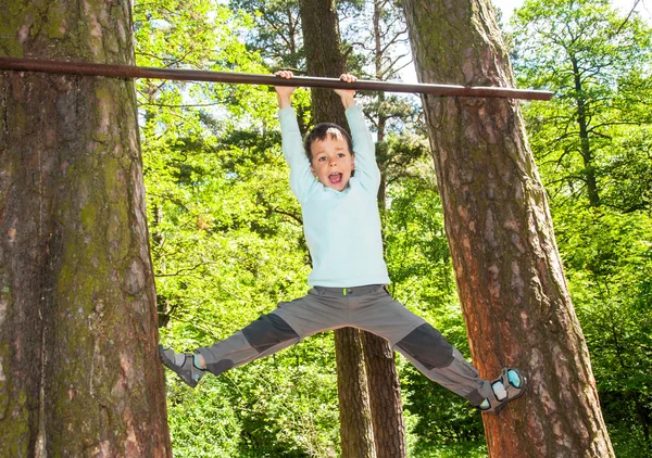 Menino fazendo pull ups ao ar livre — Fotografia de Stock