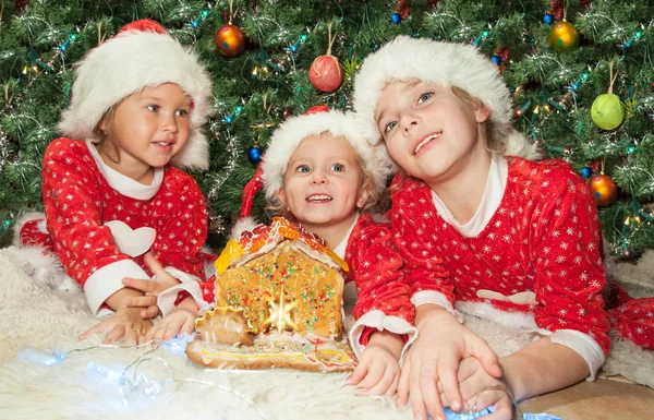Kids decorating a gingerbread house — Stock Photo, Image
