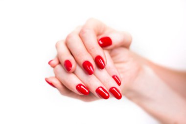 Tırnak Tasarımı. Beyaz arka planda Parlak Kırmızı Noel Manikürlü Eller. Kadın Ellerinin Kapanışı. Sanat Tırnağı.