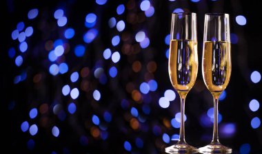 Noel aydınlatmaları ve şampanya kadehleri. - Mutlu yıllar. Noel ve Yeni Yıl tatilleri