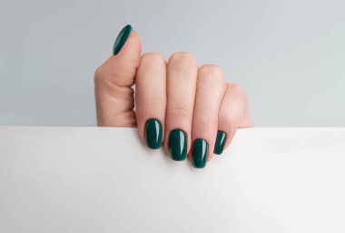 Manikürlü kadın eli, elinde fotokopi alanı olan boş bir kağıt tutuyor..