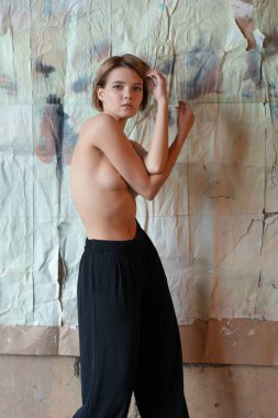 Stüdyoda çıplak poz veren genç ve güzel bir kadın.