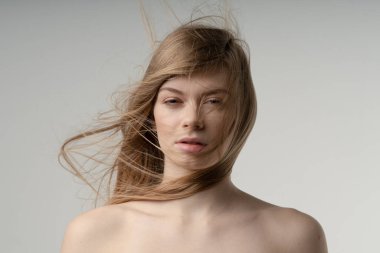 portrait of young beautiful woman in studio with fluffy hair