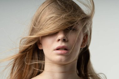 Kabarık saçlı güzel bir kızın portresi.