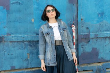 Dışarıda poz veren genç, güzel bir kadın: mavi kot ceketli.