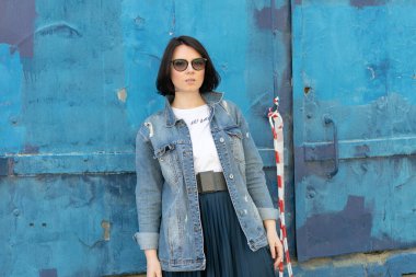 Dışarıda poz veren genç, güzel bir kadın: mavi kot ceketli.