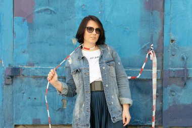 Dışarıda poz veren genç, güzel bir kadın: mavi kot ceketli.