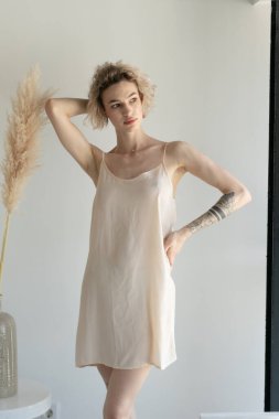 Genç ve güzel bir kadın stüdyoda beyaz iç çamaşırlarıyla poz veriyor.