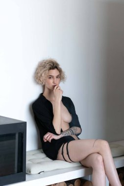 Genç ve güzel bir kadın stüdyoda sigara içiyor.