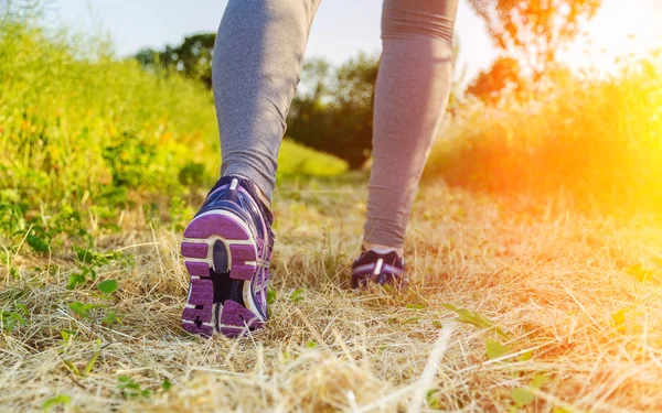 Donna che corre al tramonto in un campo — Foto Stock