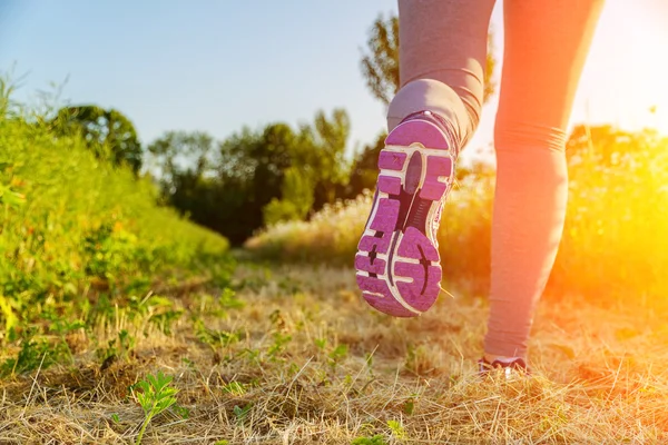 Donna che corre al tramonto in un campo — Foto Stock