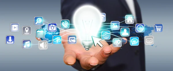 Бизнесмен держит лампочку с цифровыми иконками — стоковое фото