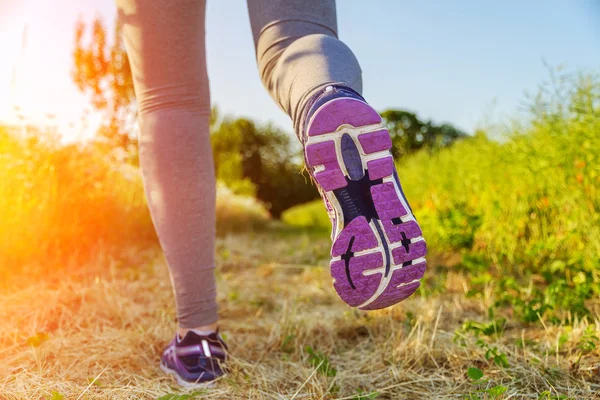 Woman running at sunset in a field — Stock Photo, Image