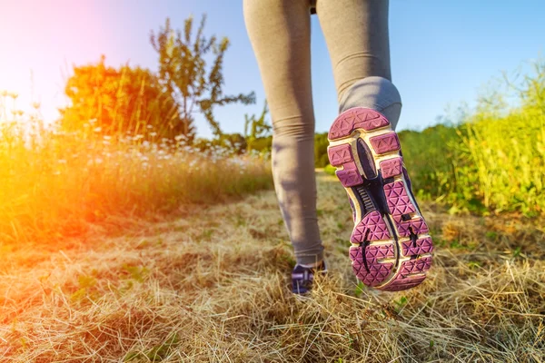 Donna che corre al tramonto in un campo — Foto Stock