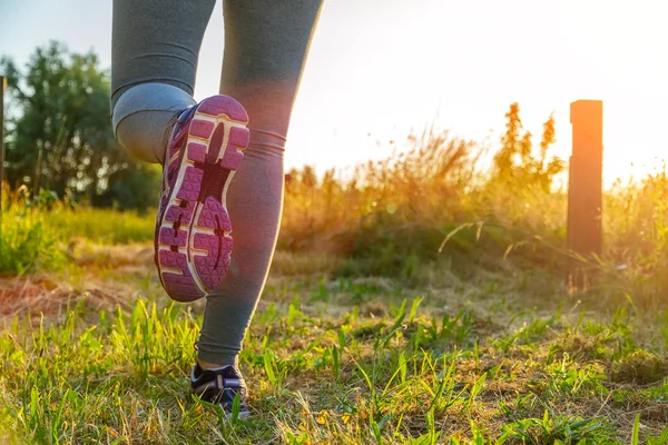 Donna che corre al tramonto in un campo — Foto Stock