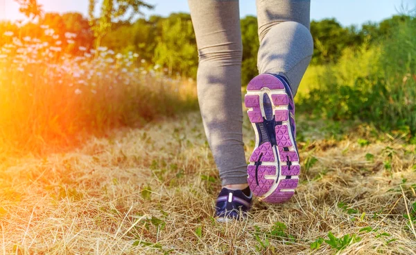 Donna che corre al tramonto in un campo — Foto Stock