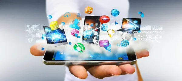 Podnikatel drží tech zařízení a ikony aplikací nad c — Stock fotografie