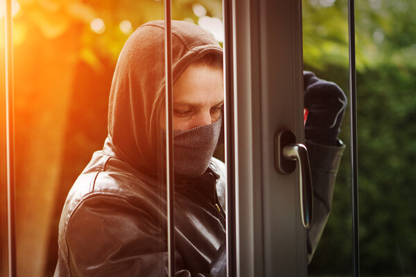 Burglar breaking in a house