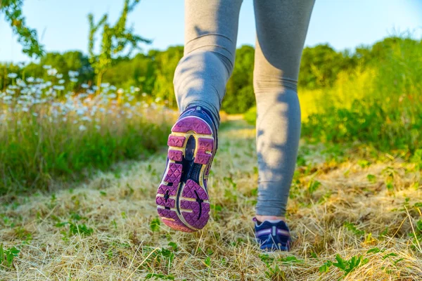 Donna che corre al tramonto in un campo — Foto Stock