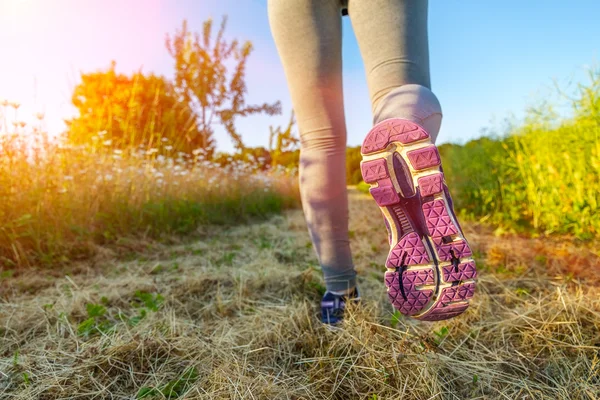 Woman running at sunset in a field — Stock Photo, Image