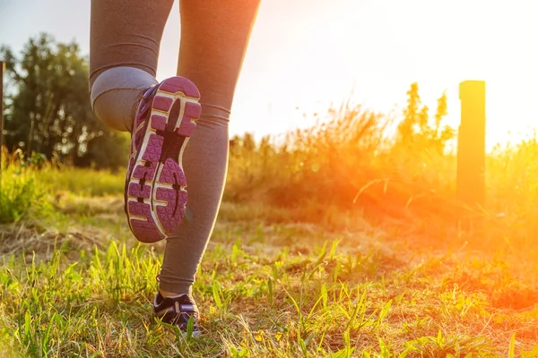 Donna che corre al tramonto in un campo — Foto Stock