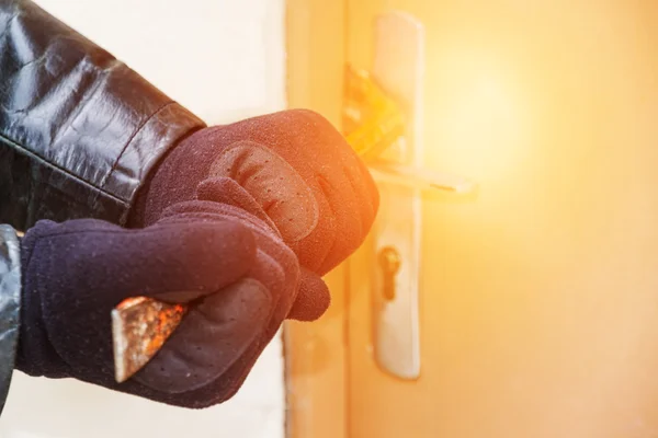 Ladrão vestindo casaco de couro quebrando em uma casa — Fotografia de Stock