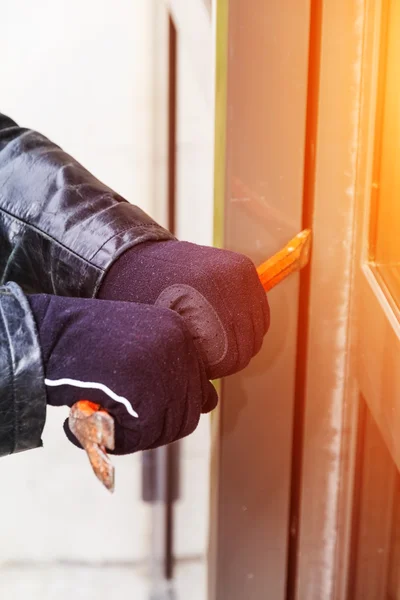 Burglar wearing leather coat breaking in a house — Stock Photo, Image