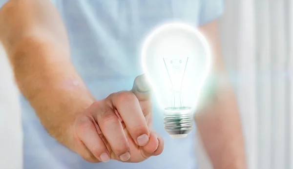 Affärsman röra glänsande glödlampa i handen — Stockfoto